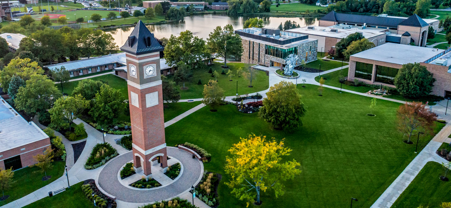 Aerial view of the Cornerstone University campus that shows academic buildings, bell tower and pond