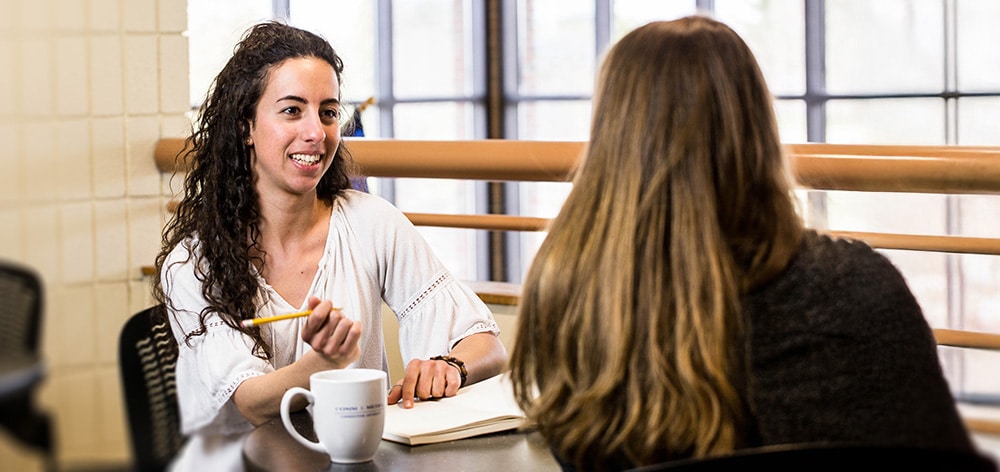 Two Cornerstone students talking over coffee