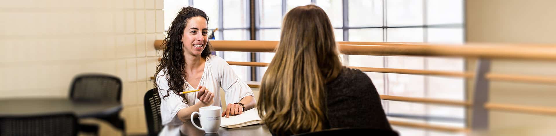 Two Cornerstone students talking over coffee