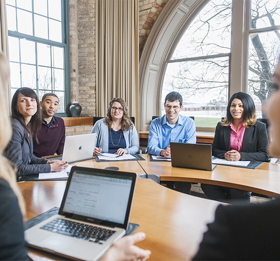 Group of graduate business students from Cornerstone University meeting in a conference room around a circular table