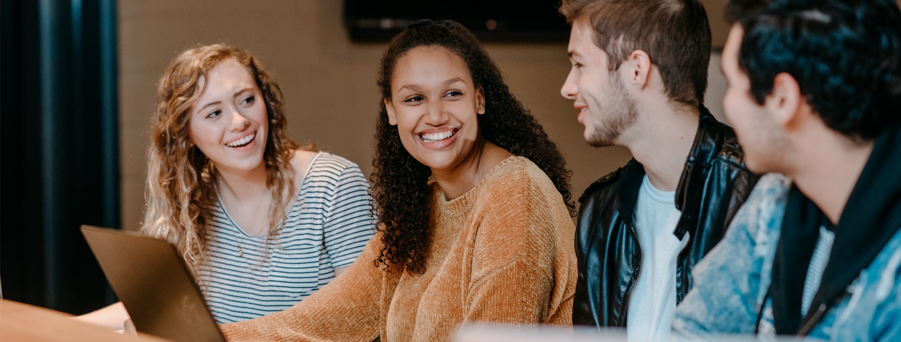 Four undergraduate college students of gender and ethnic diversity studying in the Corum Student Union at Cornerstone University