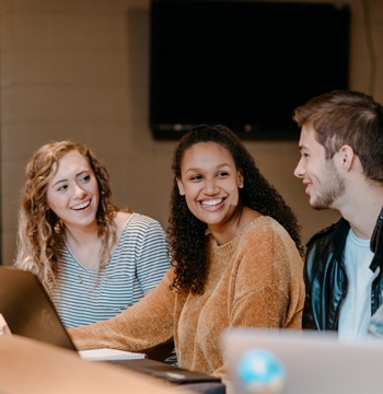 Four undergraduate college students of gender and ethnic diversity studying in the Corum Student Union at Cornerstone University