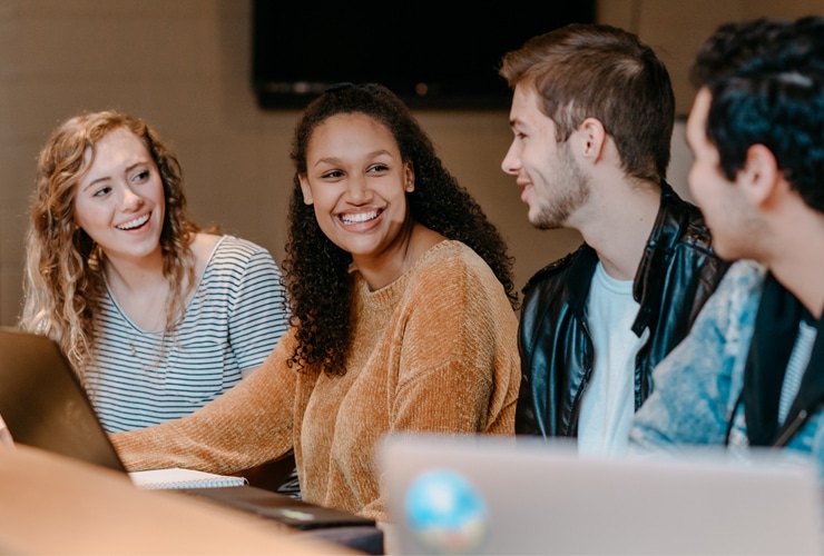 Four undergraduate college students of gender and ethnic diversity studying in the Corum Student Union at Cornerstone University