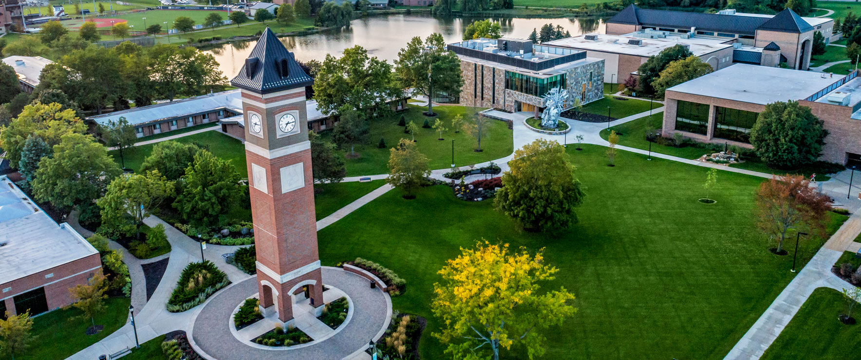 Aerial view of the Cornerstone University campus that shows academic buildings, bell tower and pond