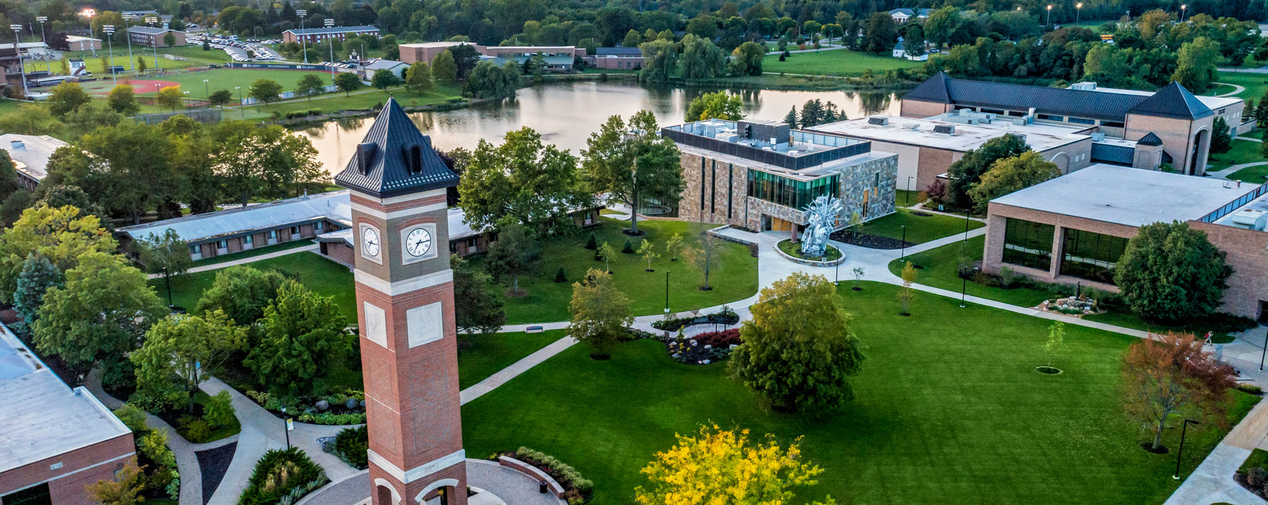 Aerial view of the Cornerstone University campus that shows academic buildings, bell tower and pond
