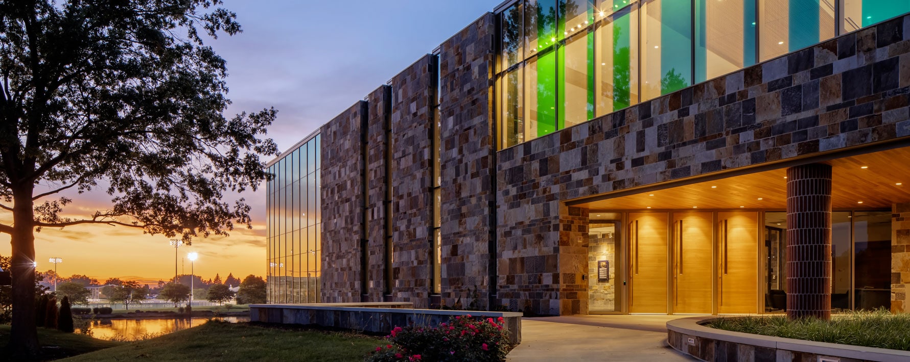 Exterior of De Witt Center for Science & Technology of Cornerstone University at dusk with the campus pond in the background