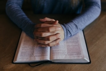 hands-over-open-bible