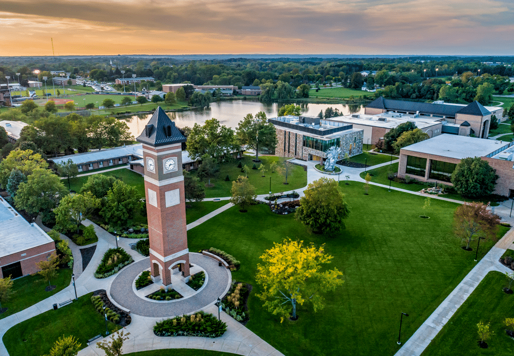 Aerial view of the Cornerstone University campus that shows academic buildings, bell tower and pond