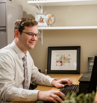 Male employee typing on his computer at his desk in his workplace