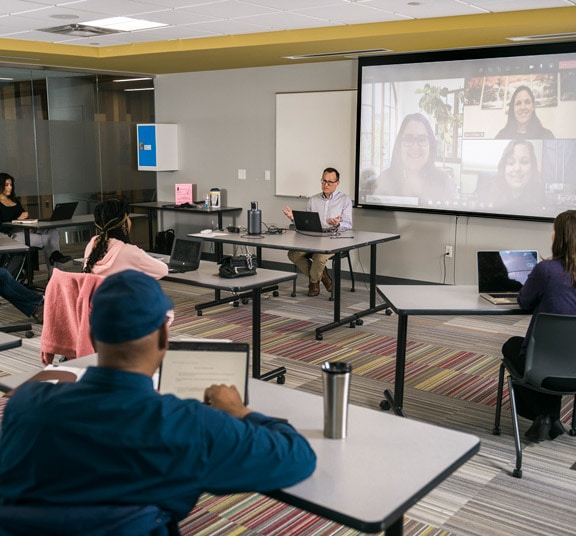 Livestreamed classroom with in-person and virtual students in a CULive classroom at Cornerstone University's Professional & Graduate Studies