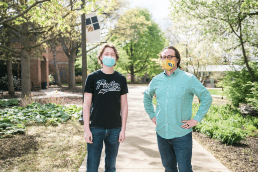 Male student and professor standing on the sidewalk located outside of the dining commons at Cornerstone University