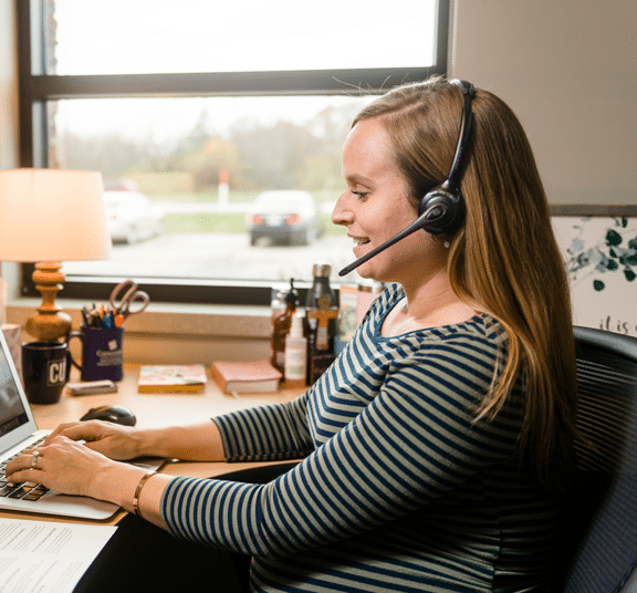 Female enrollment counselor meeting via phone while sitting in her office at Cornerstone University