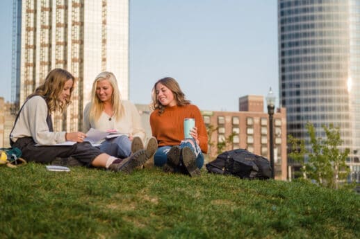 Three undergraduate students from Cornerstone University studying outside on grassy hill in Grand Rapids, MichiganThree undergraduate students from Cornerstone University studying outside on grassy hill in Grand Rapids, Michigan