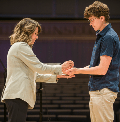 Female nursing faculty member anoints hands of incoming nursing student with oil during Blessing of the Hands ceremony at Cornerstone University
