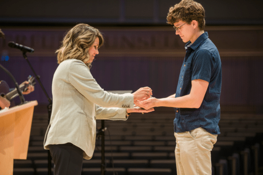 Female nursing faculty member anoints hands of incoming nursing student with oil during Blessing of the Hands ceremony at Cornerstone University