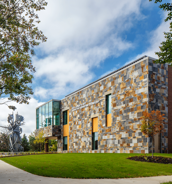 Exterior of De Wiitt Center for Science and Technology at Cornerstone University with Christ Chapel visible in the distance