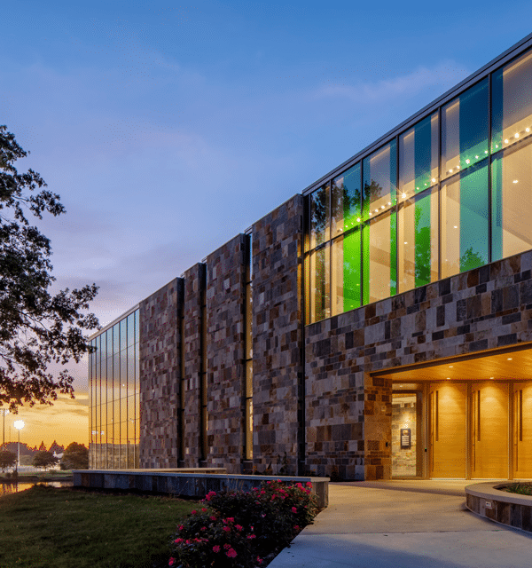 Exterior of De Witt Center for Science and Technology of Cornerstone University at dusk with the campus pond in the background