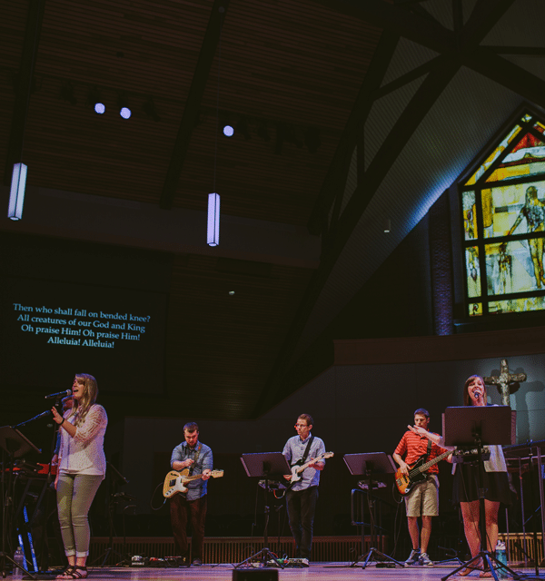 Worship team comprised of five undergraduate college students and one staff member leading worship on the stage in Christ Chapel at Cornerstone University