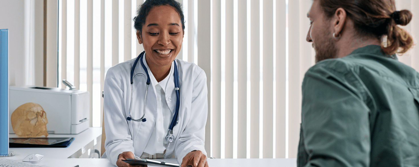 Female health care professional communicating with patient at a desk