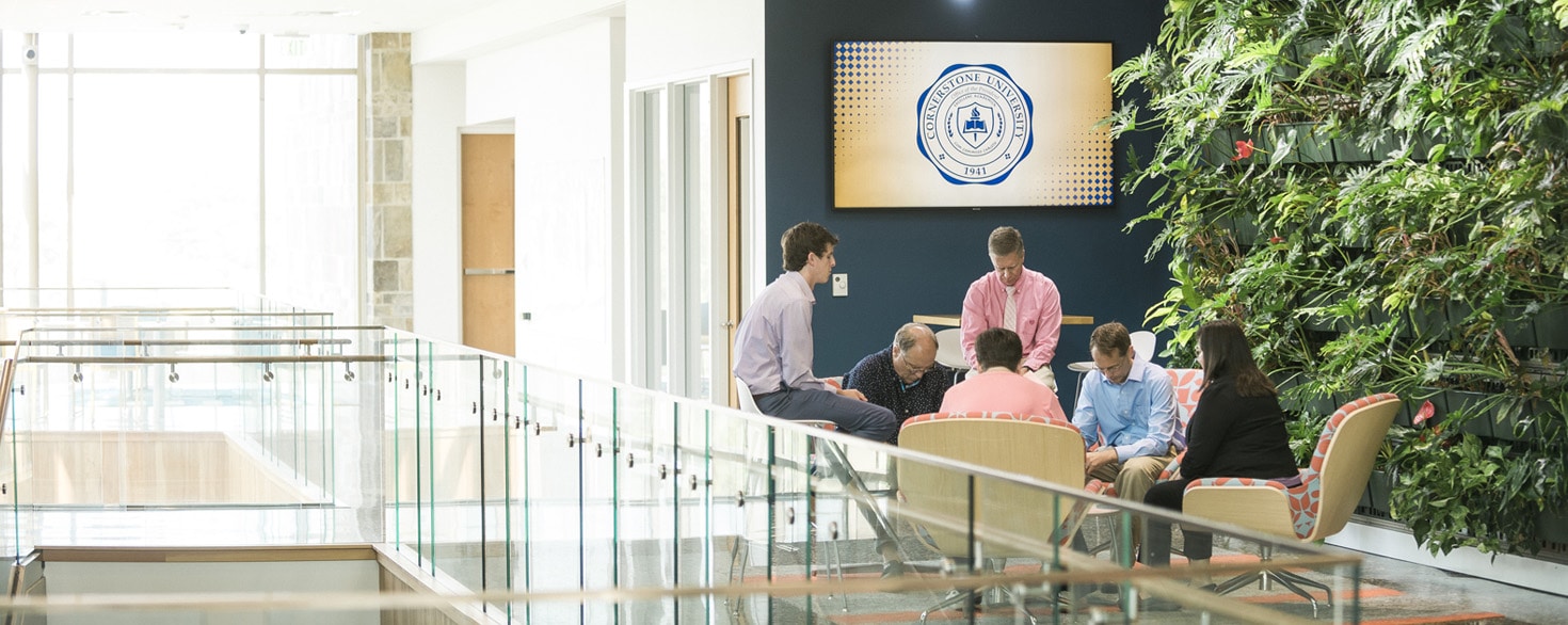Cornerstone University staff praying in the atrium of De Witt Center for Science and Technology at Cornerstone University