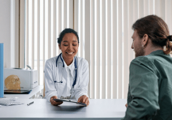 Female health care professional communicating with patient at a desk