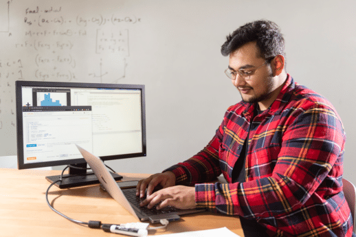 Male student typing on a laptop in a data engineering classroom