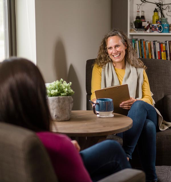 Female counselor meeting with a female client by a round table in an office setting