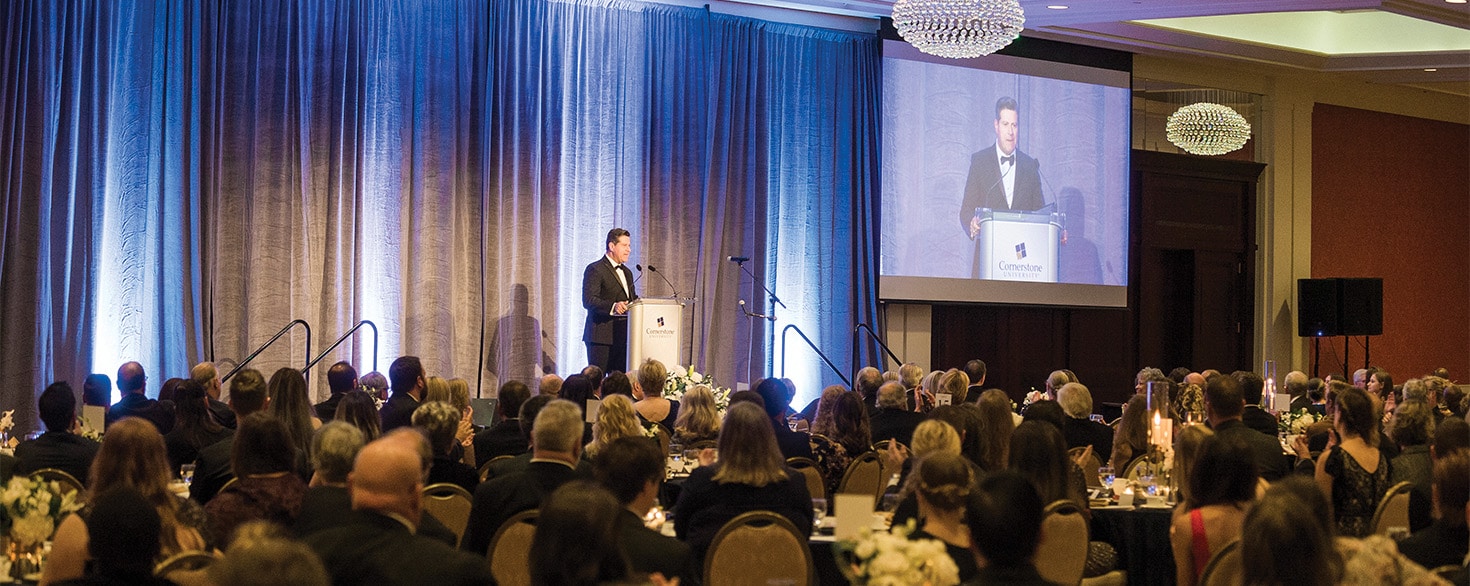Gerson Moreno-Riaño speaks from podium on stage to Inaugural Gala attendees