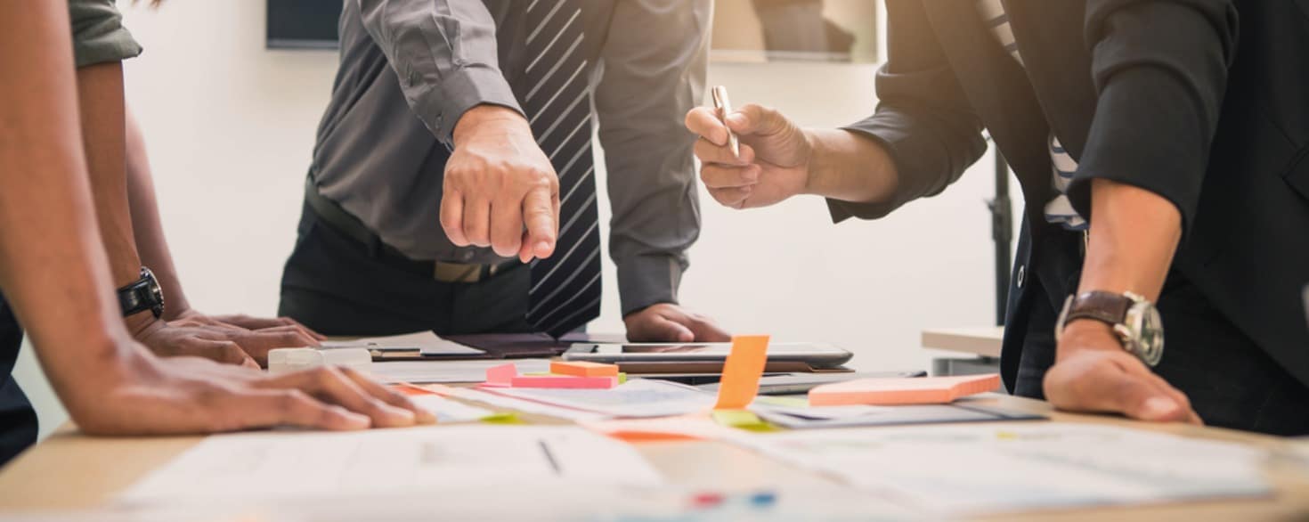 Several employees gathered around a table while working on a business plan