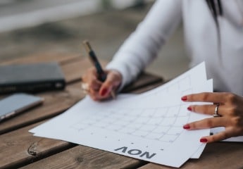 Female sitting at a table writing on a calendar