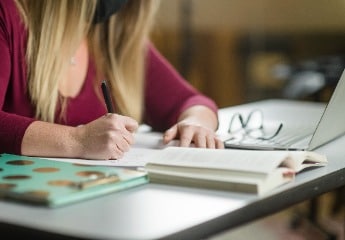 Female student writing in notebook at Cornerstone University