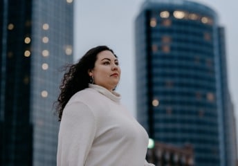 Female student standing outside in front of downtown Grand Rapids