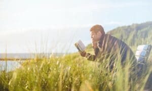 Man sitting outside reading a book