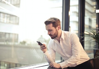 Man holding a smartphone in his hand while sitting down