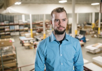 Male student standing confidently in his workplace