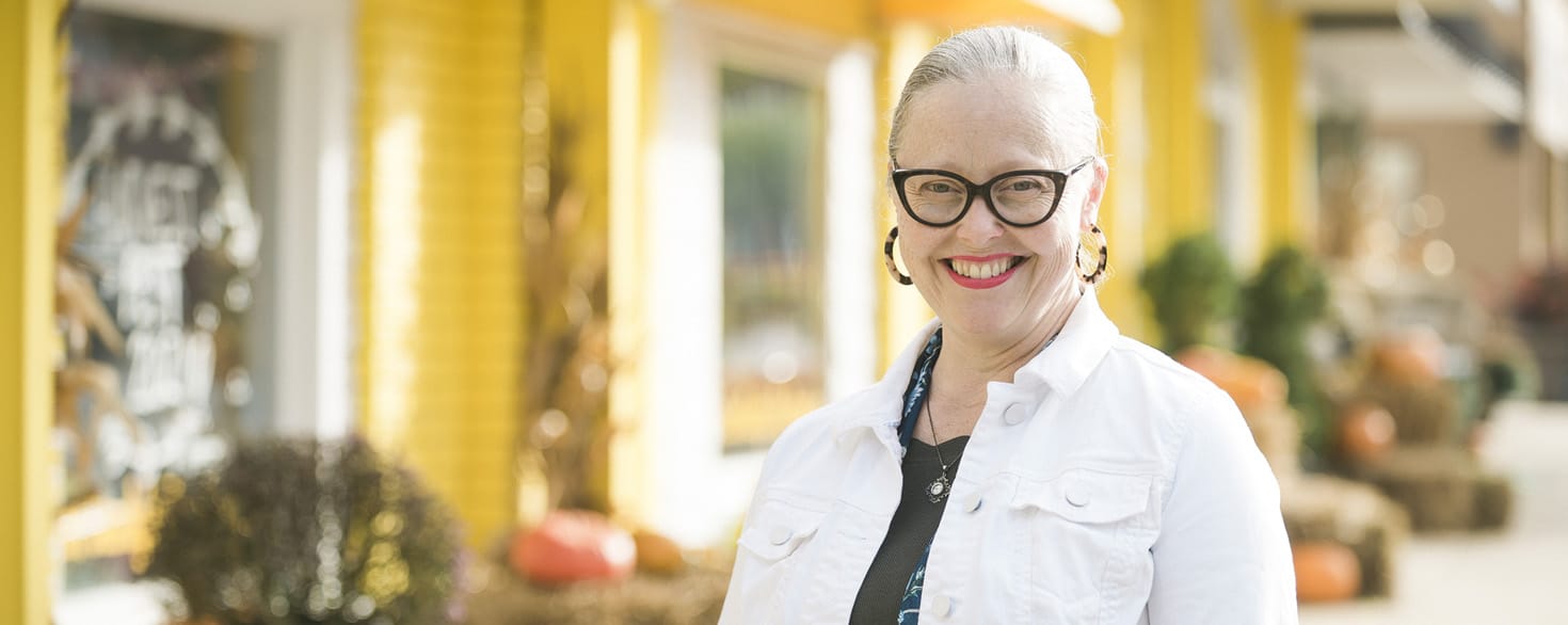Ellen Moreno-Riaño standing on a sidewalk outside a storefront in Rockford, Michigan