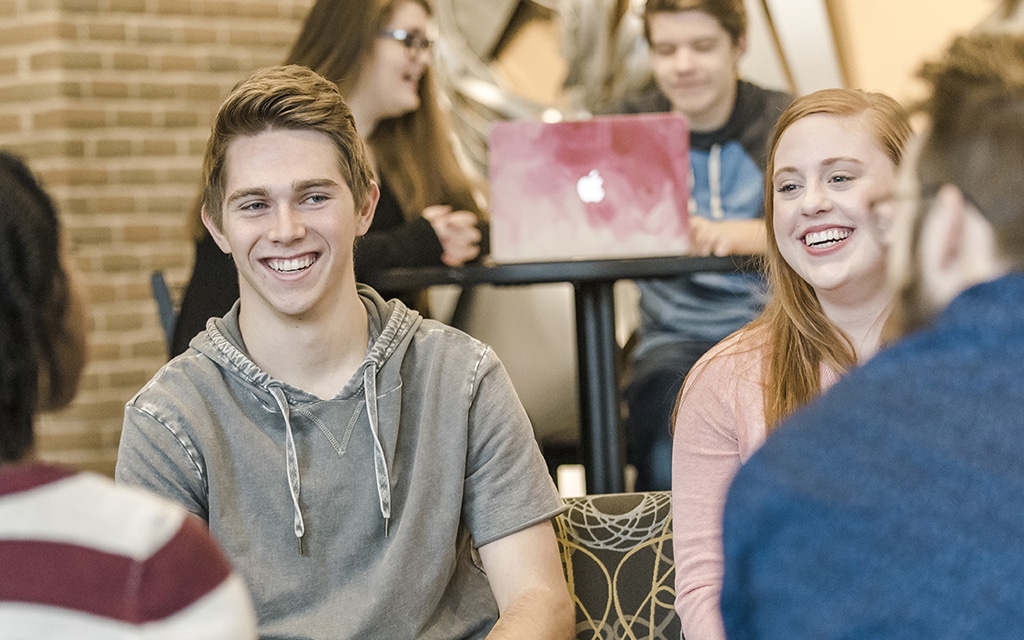 Male and female students talking in the lobby of Christ Chapel at Cornerstone University