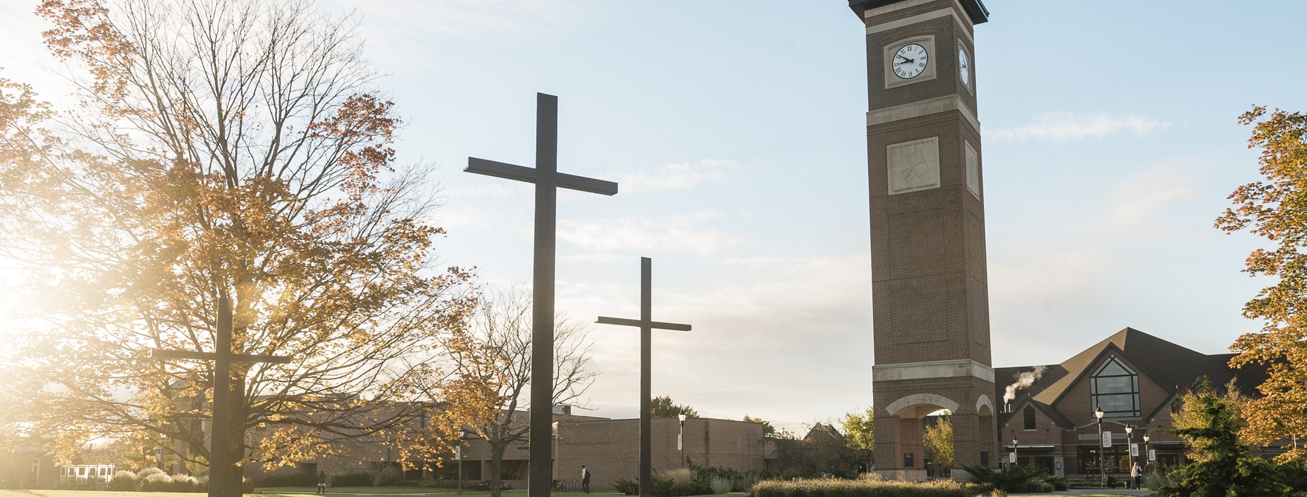 Three crosses statue located near the sidewalk leading to the campus bell tower and Christ Chapel at Cornerstone University