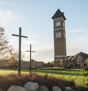 Three crosses statue located near the sidewalk leading to the campus bell tower and Christ Chapel at Cornerstone University