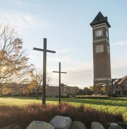 Three crosses statue located near the sidewalk leading to the campus bell tower and Christ Chapel at Cornerstone University