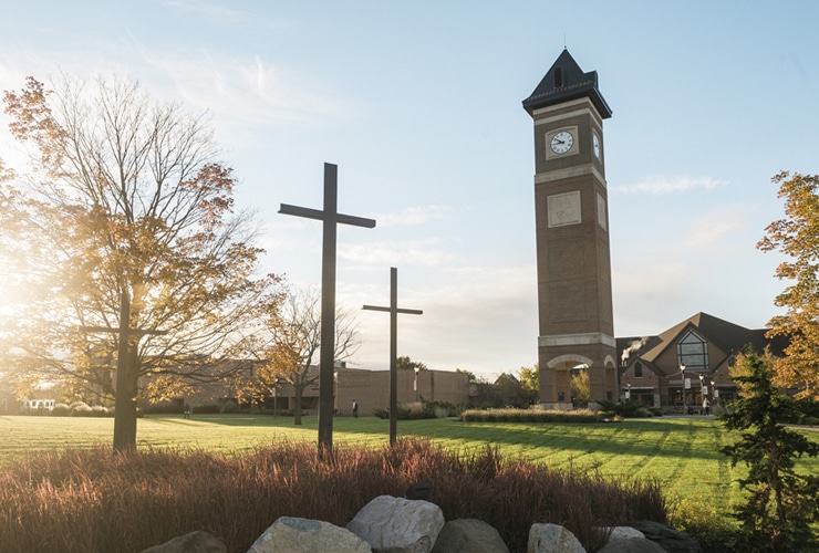 Three crosses statue located near the sidewalk leading to the campus bell tower and Christ Chapel at Cornerstone University