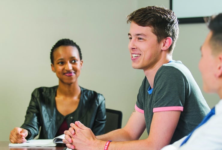 Male and female college students meeting in a classroom