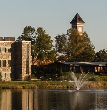 Cornerstone University campus pond and fountain with De Witt Center for Science & Technology and campus bell tower in the background