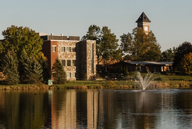 Cornerstone University campus pond and fountain with De Witt Center for Science & Technology and campus bell tower in the background