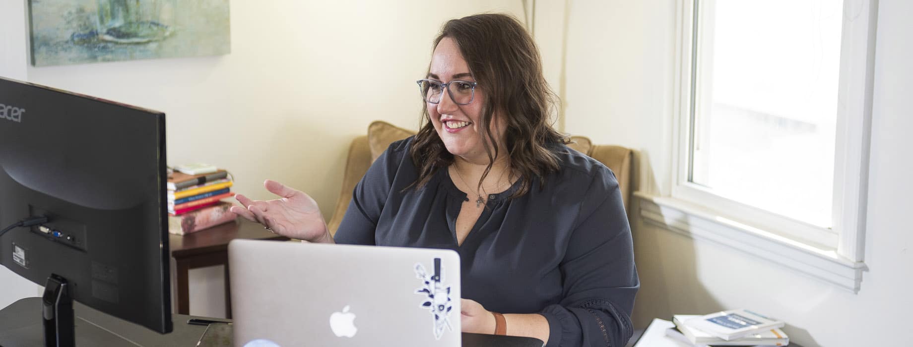 Female graduate student taking an online class on a laptop in a home living room