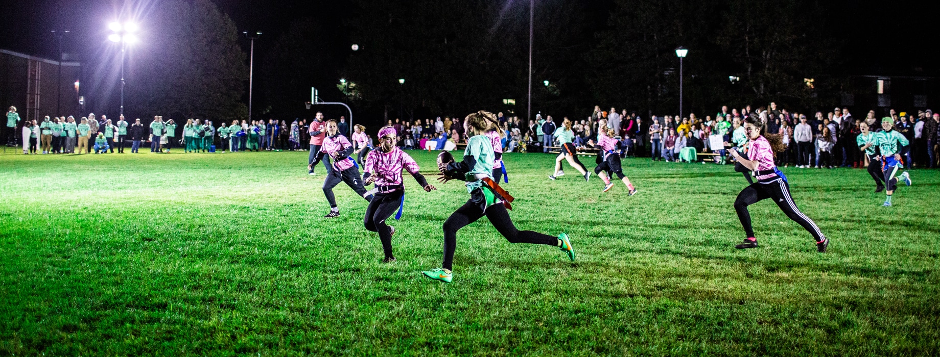 Female students playing Powderpuff football in the evening at Cornerstone University