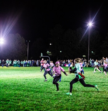 Female students playing Powderpuff football in the evening at Cornerstone University