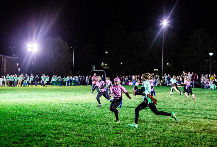 Female students playing Powderpuff football in the evening at Cornerstone University