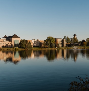 Cornerstone University athletic facility, science building and bell tower located near campus pond