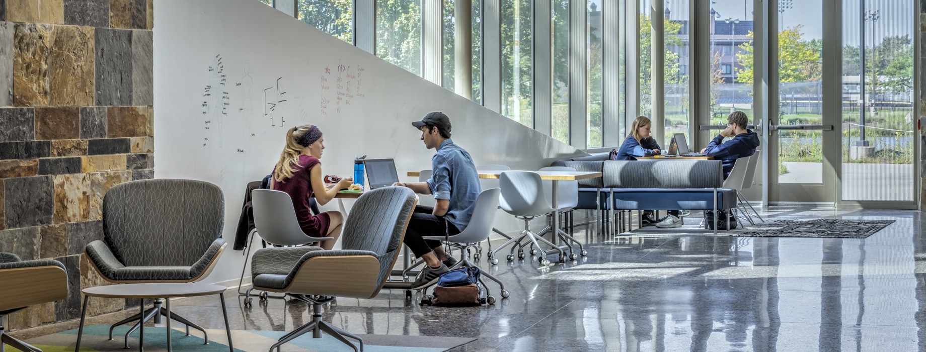 College students studying near windows in the De Witt Center for Science and Technology